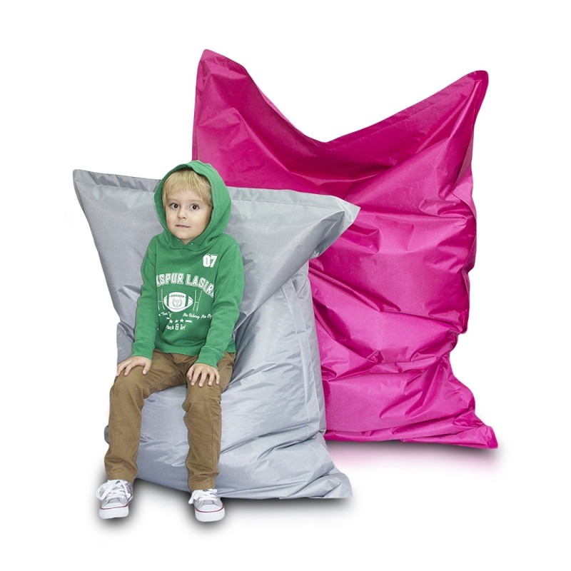 Гигантска синя възглавница за сядане NC6 в модерна всекидневна, до диван, служеща като декоративен елемент и допълнително място за релакс.